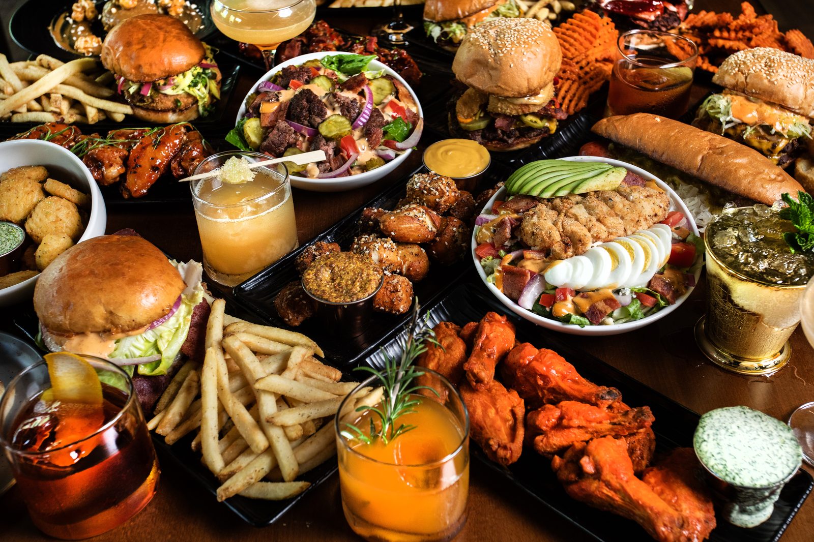 A full Ground Rules spread — burgers, wings, sides and cocktails.